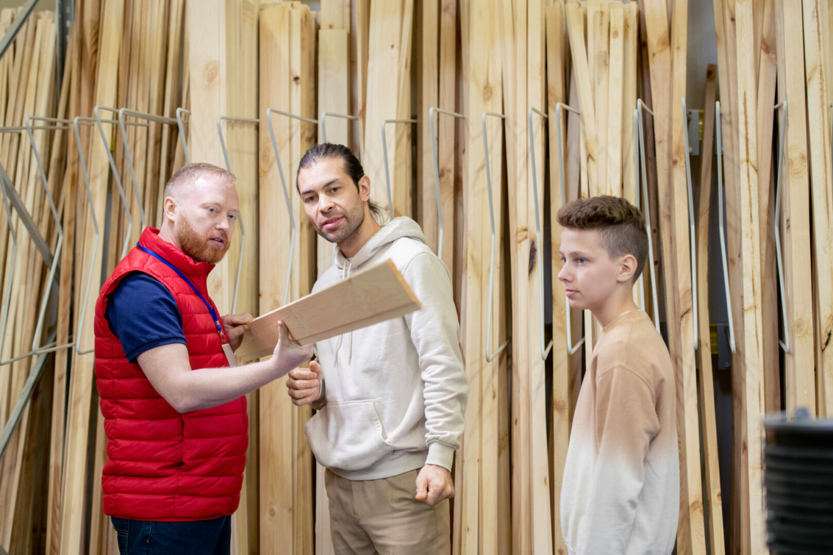 Bearded shop assistant showing wooden board to buyers